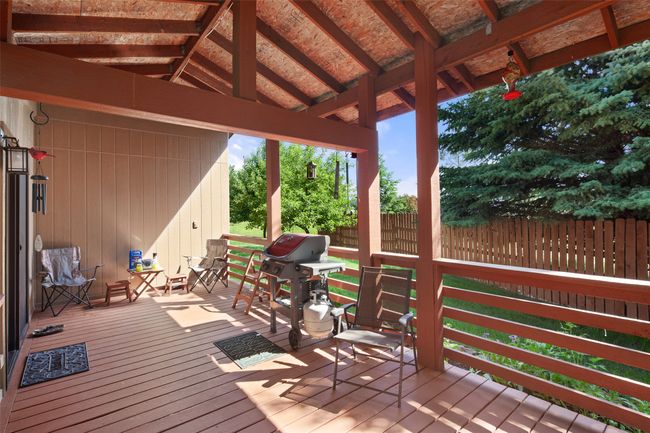 Deck with a grill and a fenced yard | Image 44