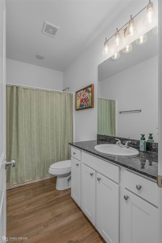 Full bath featuring toilet, wood finished floors, vanity, and visible vents | Image 24