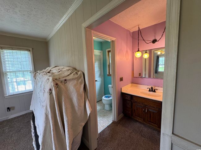 Bathroom with a textured ceiling, vanity, and ornamental molding | Image 14