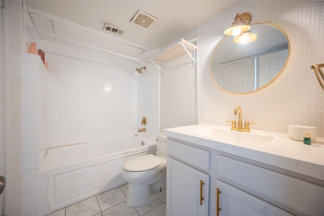 Bathroom with marble finish floor, toilet, vanity, and visible vents | Image 4