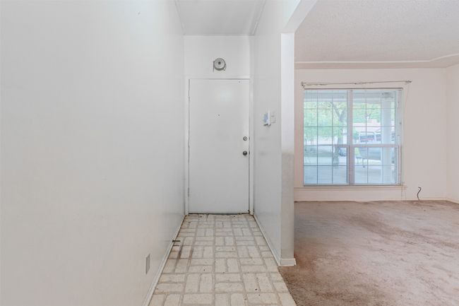 Entrance foyer featuring baseboards, brick floor, and light colored carpet | Image 5