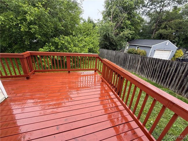 Wooden terrace featuring a fenced backyard and a garage | Image 15