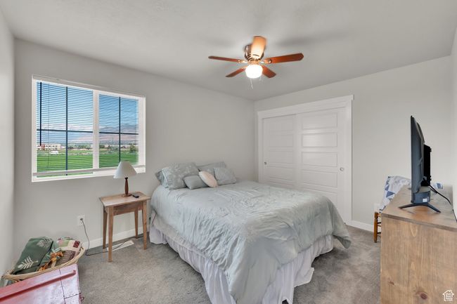 Bedroom with carpet floors, a closet, and ceiling fan | Image 16