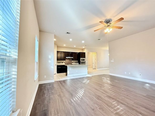 Unfurnished living room with ceiling fan, recessed lighting, and light wood finished floors | Image 11