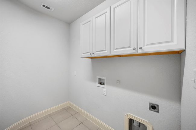 Laundry room featuring hookup for a washing machine, visible vents, cabinet space, electric dryer hookup, and hookup for a gas dryer | Image 7