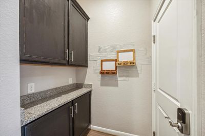 When you enter through the garage there is a drop zone with cabinets and granite countertops for added storage. | Image 3