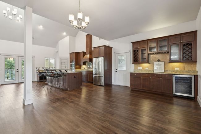 Kitchen featuring pendant lighting, stainless steel appliances, dark wood-type flooring, and wine cooler | Image 6