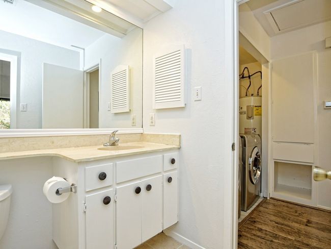 Bathroom featuring toilet, water heater, wood finished floors, and vanity | Image 12
