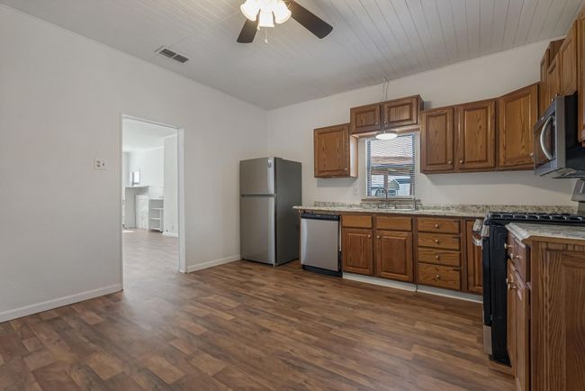 Kitchen featuring sink, dark wood-type flooring, ceiling fan, stainless steel appliances, and wooden ceiling | Image 15