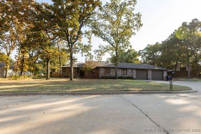 Front of home dressed in large mature trees. | Image 1