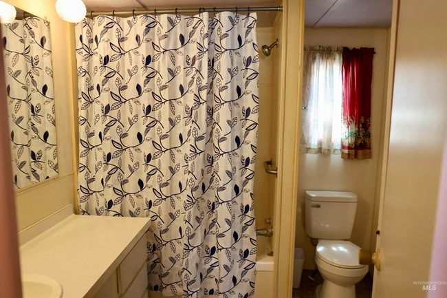 Full bath featuring vanity and shower / bath combination with curtain | Image 12