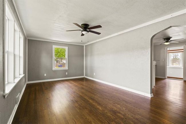 Spare room with ceiling fan, wood-type flooring, arched walkways, and a textured ceiling | Image 4