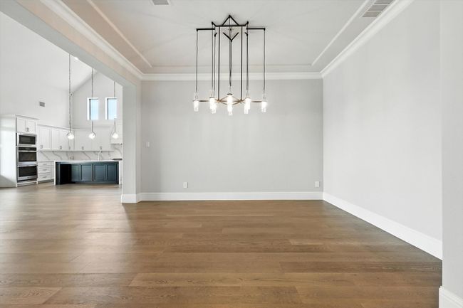 Unfurnished dining area with wood finished floors and crown molding | Image 7