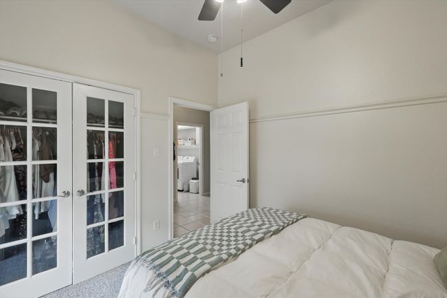 Bedroom with french doors, washer / dryer, ceiling fan, and tile patterned floors | Image 33