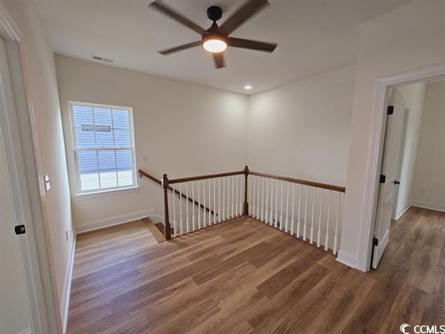 Empty room with a ceiling fan, visible vents, baseboards, and wood finished floors | Image 29