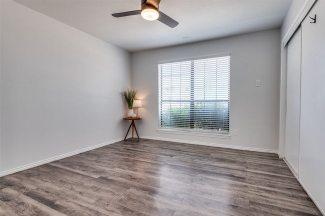 Spacious bedroom with LVP flooring and a new remote controlled ceiling fan and light. Large closet and natural light. | Image 7
