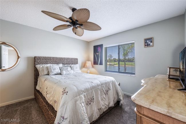 Bedroom with baseboards, dark colored carpet, and a textured ceiling | Image 9