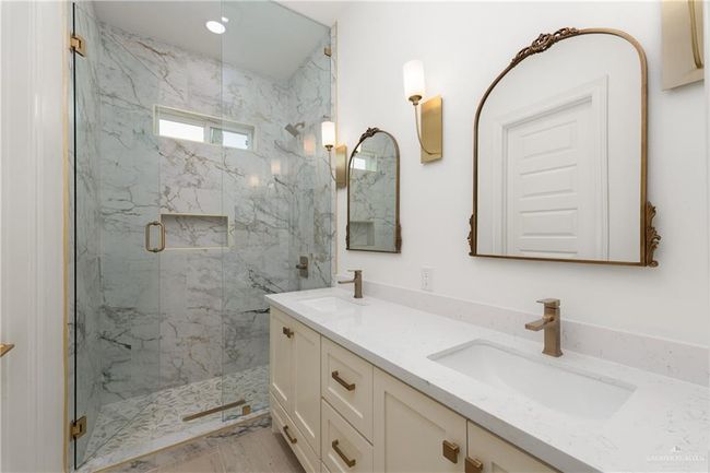 Chic Powder RoomClassic powder room with sleek quartz vanity, antique gold mirror, and designer wall sconces—perfect for guests. | Image 24