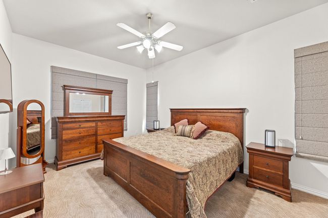 Bedroom with light colored carpet, baseboards, and a ceiling fan | Image 28