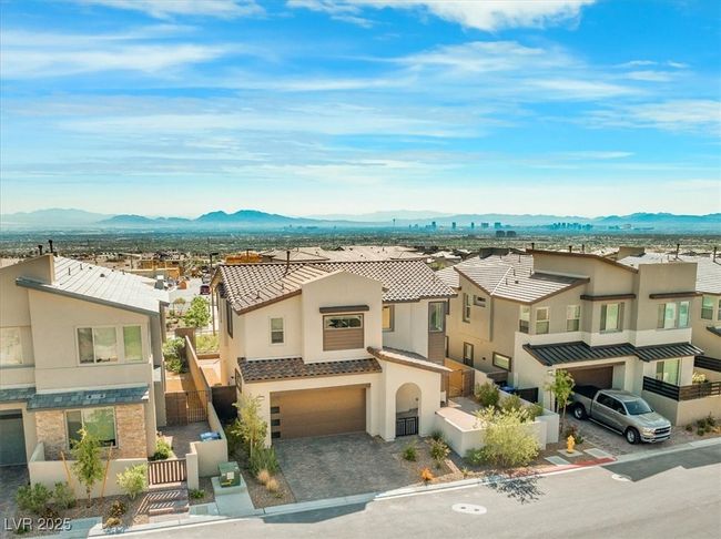 View of front of house featuring a garage, fence private yard, a gate, a mountain view, and stucco siding | Image 60
