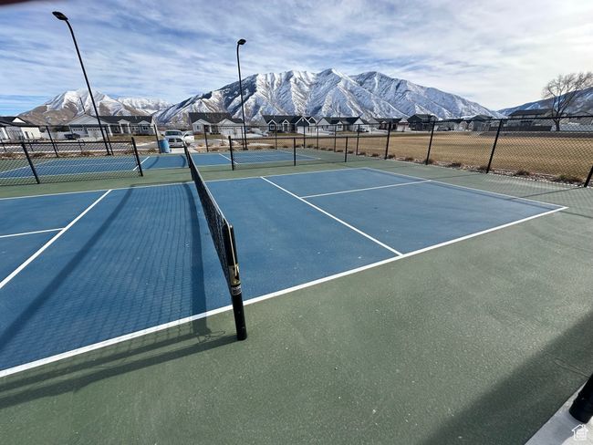 View of sport court with a mountain view, a residential view, and fence | Image 11