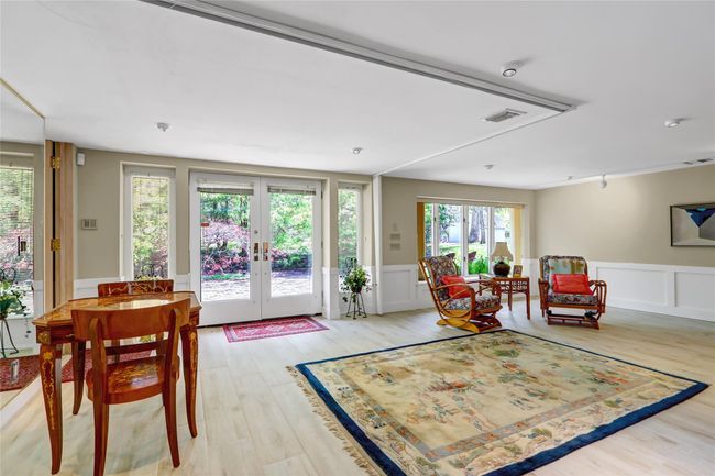 Sitting room featuring light wood-style floors, a wainscoted wall, visible vents, a decorative wall, and french doors | Image 26
