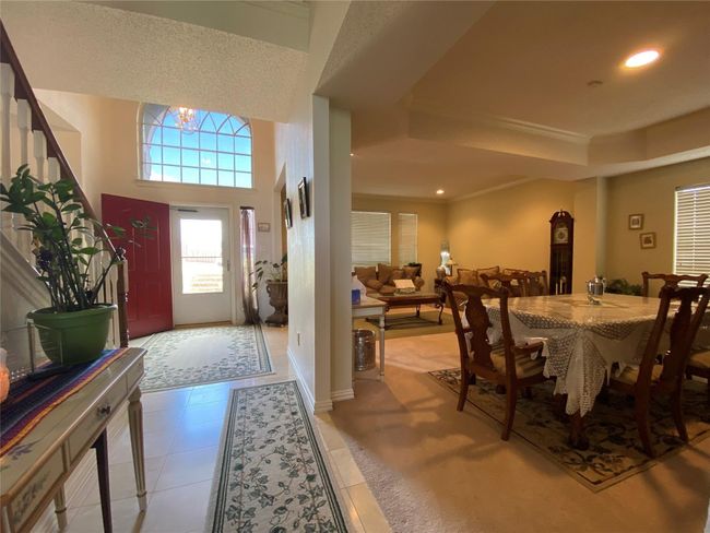 Tiled foyer entrance with a tray ceiling, crown molding, and a notable chandelier | Image 7