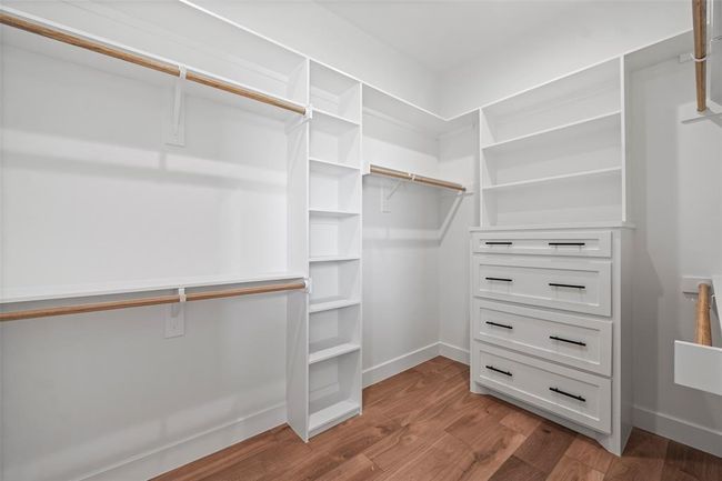 Spacious His walk-in closet in the primary bedroom, offering ample storage and elegant organization. | Image 26
