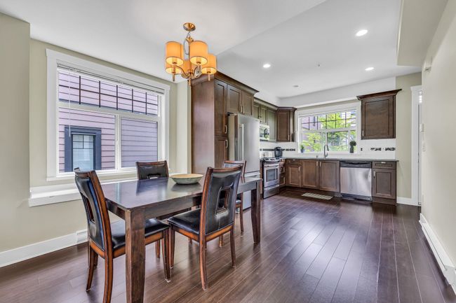 Dining area featuring a chandelier, dark wood-style flooring, baseboards, and recessed lighting | Image 9