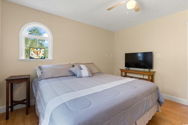 Bedroom featuring wood finished floors, baseboards, and a ceiling fan | Image 16