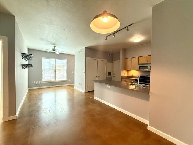 Kitchen with stainless steel appliances, baseboards, a ceiling fan, track lighting, and a textured ceiling | Image 5