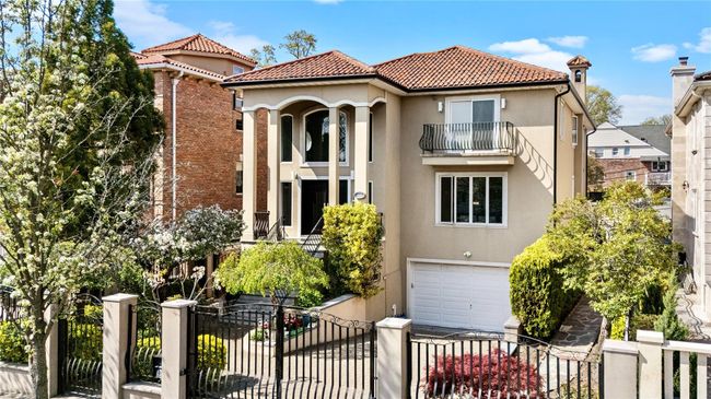 Mediterranean / spanish house featuring stucco siding, a tile roof, a fenced front yard, and a garage | Image 17