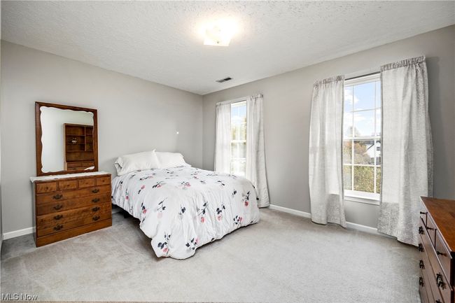Carpeted bedroom with a textured ceiling | Image 25