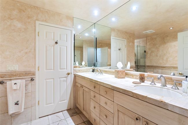 Full bath with double vanity, tile walls, recessed lighting, and an enclosed shower | Image 54