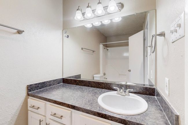 Bathroom with vanity, toilet, and a textured wall | Image 34
