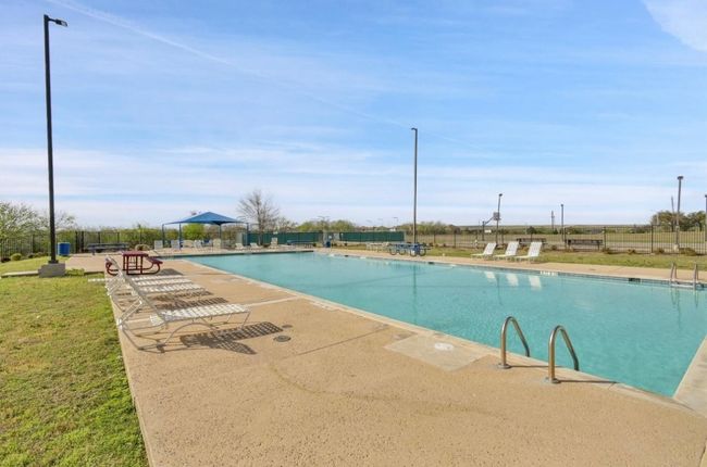Community pool with fence and a patio area | Image 24