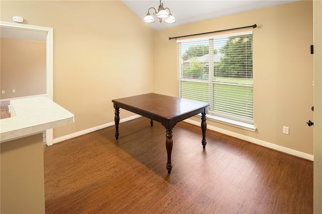 Dining area with large window looking out the back. | Image 9