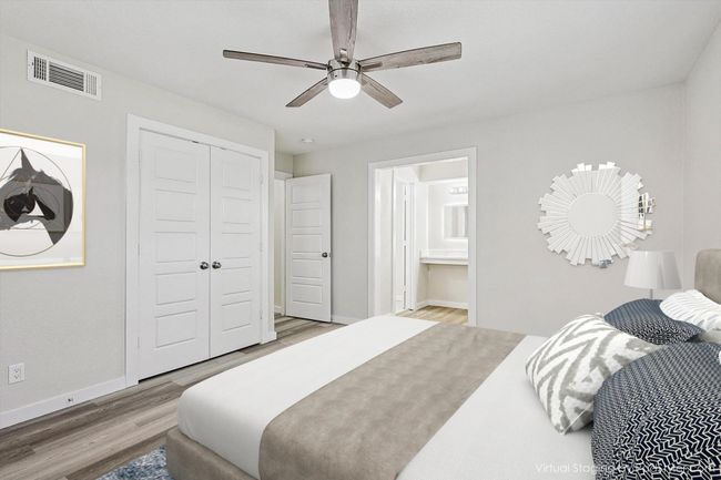 Bedroom featuring visible vents, a closet, baseboards, wood finished floors, and ensuite bath | Image 23