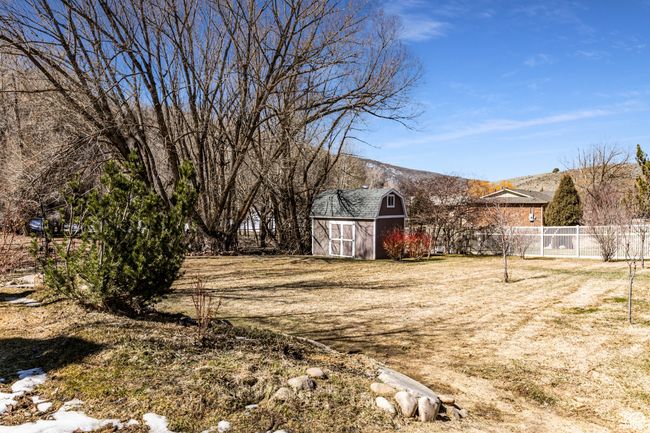 View of yard with an outbuilding, a storage unit, and fence | Image 36