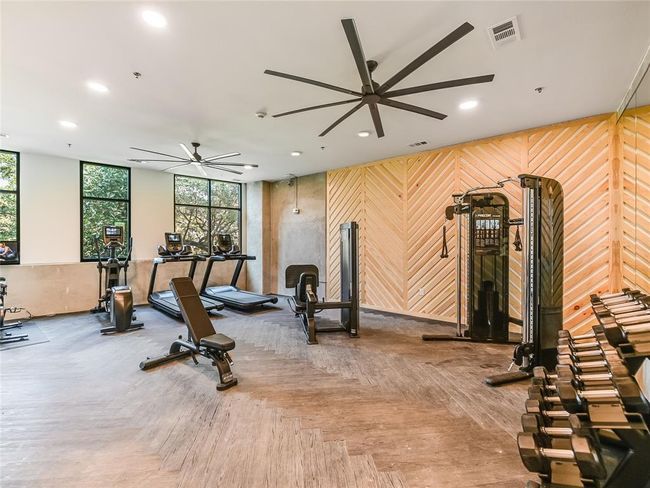 Workout area featuring a ceiling fan, recessed lighting, and wooden walls | Image 29