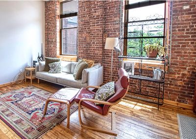 The living room is sunny and airy-note the oversized windows. | Image 3