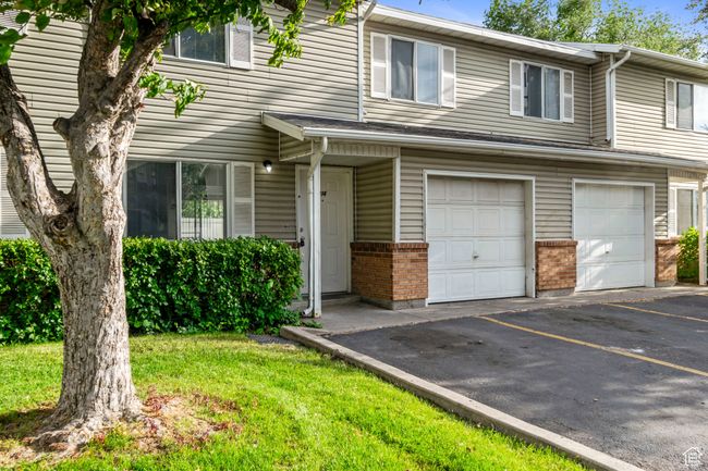 Multi unit property featuring an attached garage, brick siding, and asphalt driveway | Image 29