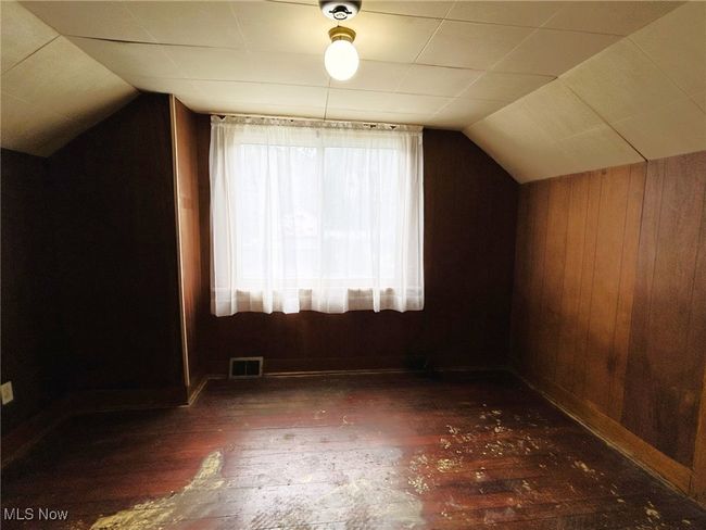 Additional living space featuring lofted ceiling, wood-type flooring, and wood walls | Image 11