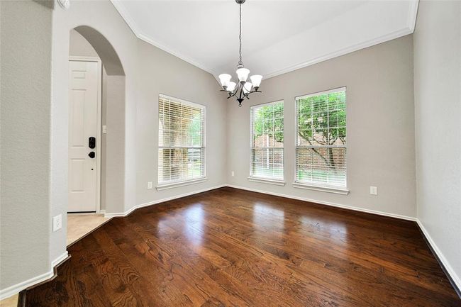 The formal dining room boasts large windows, gleaming wood floors, and crown molding making this a beautiful entertaining space. | Image 4