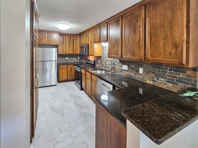 Kitchen offers new LVT flooring and all new stainless steel appliances. This a cooks kitchen. | Image 1