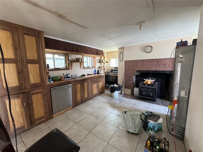 Kitchen with brown cabinets, a healthy amount of sunlight, and appliances with stainless steel finishes | Image 10