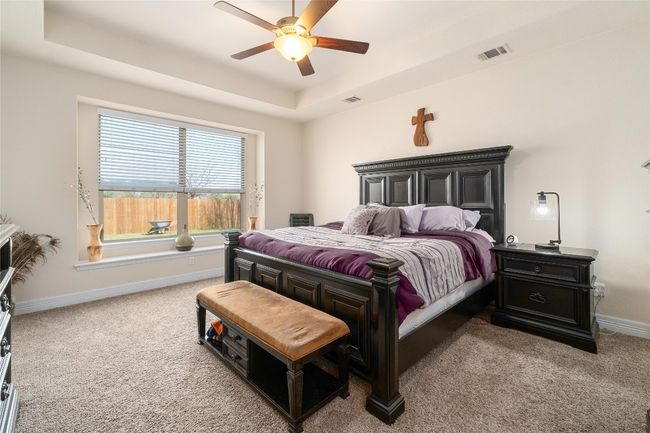 Bedroom with baseboards, a tray ceiling, carpet, and visible vents | Image 14