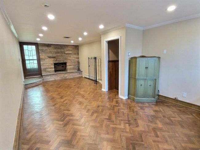 Unfurnished living room featuring baseboards, recessed lighting, crown molding, a baseboard radiator, and a fireplace | Image 24