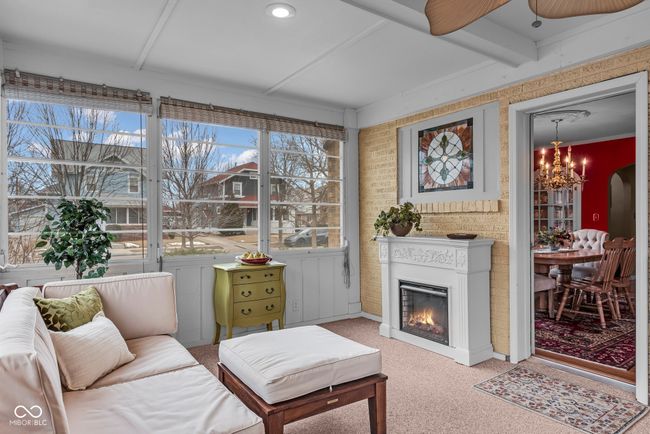 interior space featuring a notable chandelier, carpet, and a glass covered fireplace | Image 25