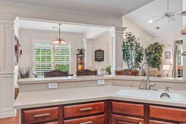 Kitchen featuring light countertops, a ceiling fan, pendant lighting, ornate columns, and vaulted ceiling | Image 18